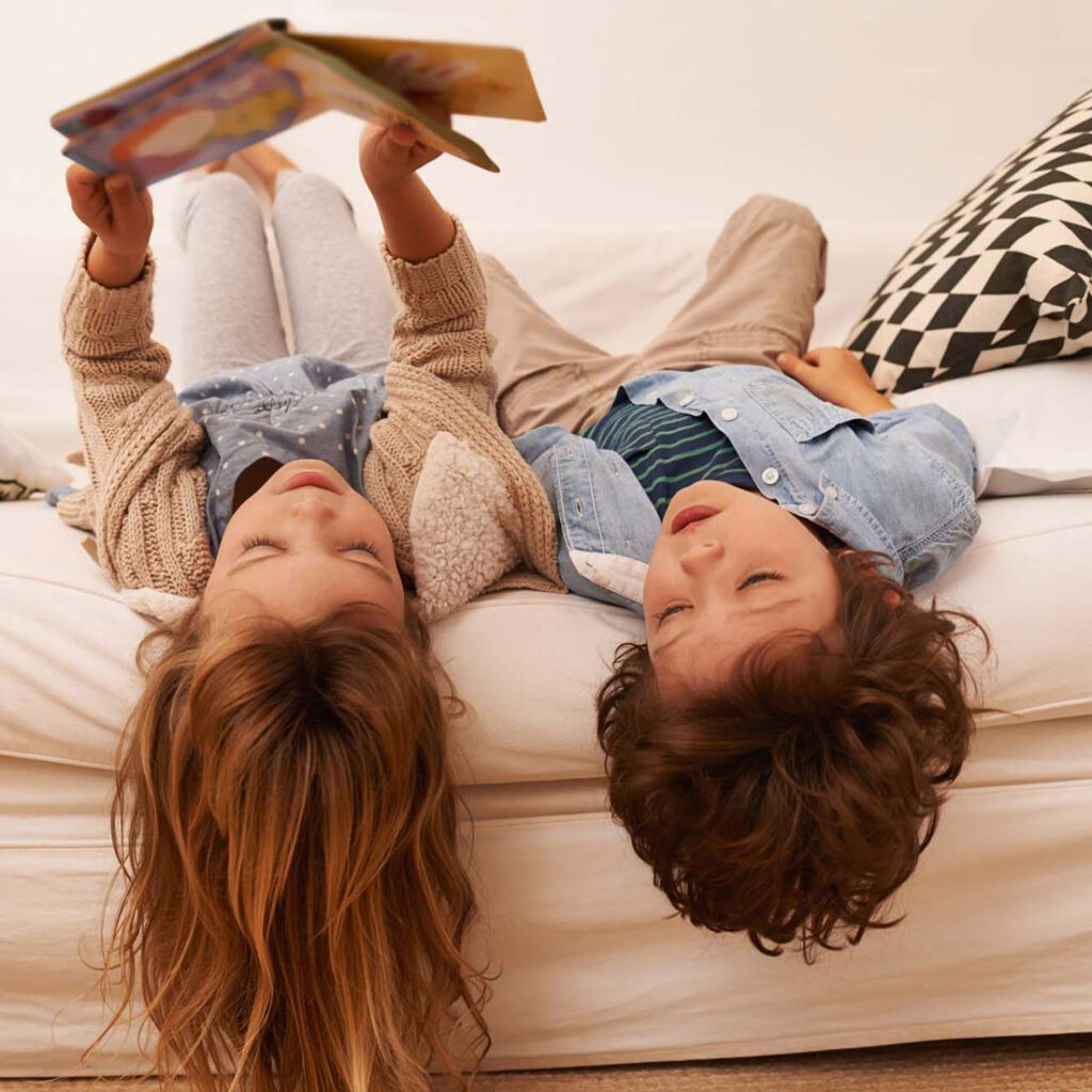 Sibling children reading a book