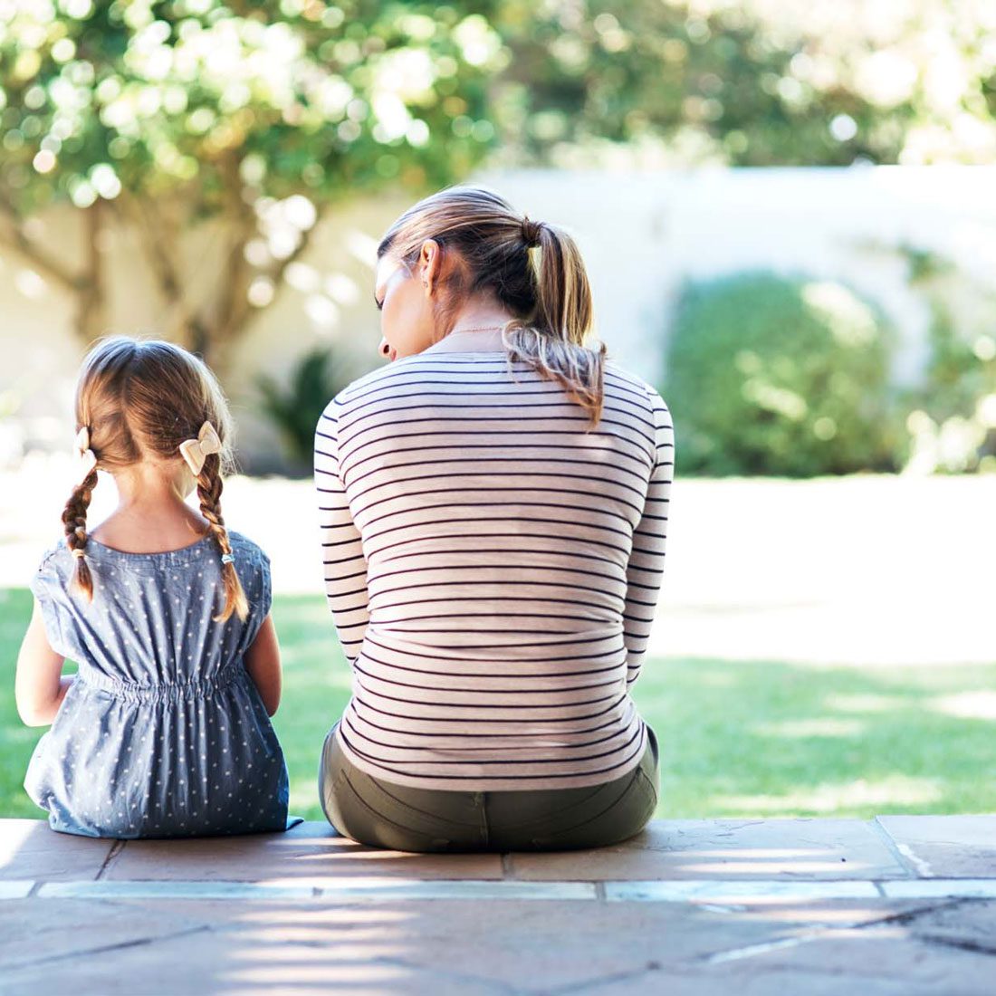 A mother and daughter together in a garden, reminiscent of the nurturing moments in the UK adoption process