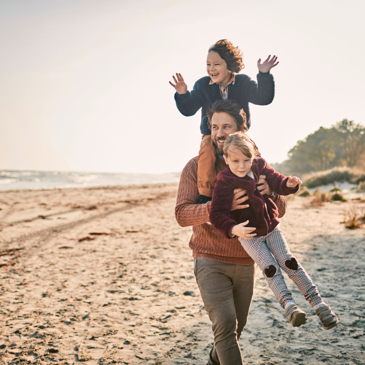 Father playing with children on the beach | Jigsaw Adoption Agency